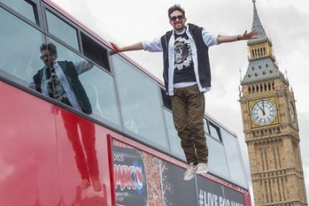 magician standing on nothing beside a bus